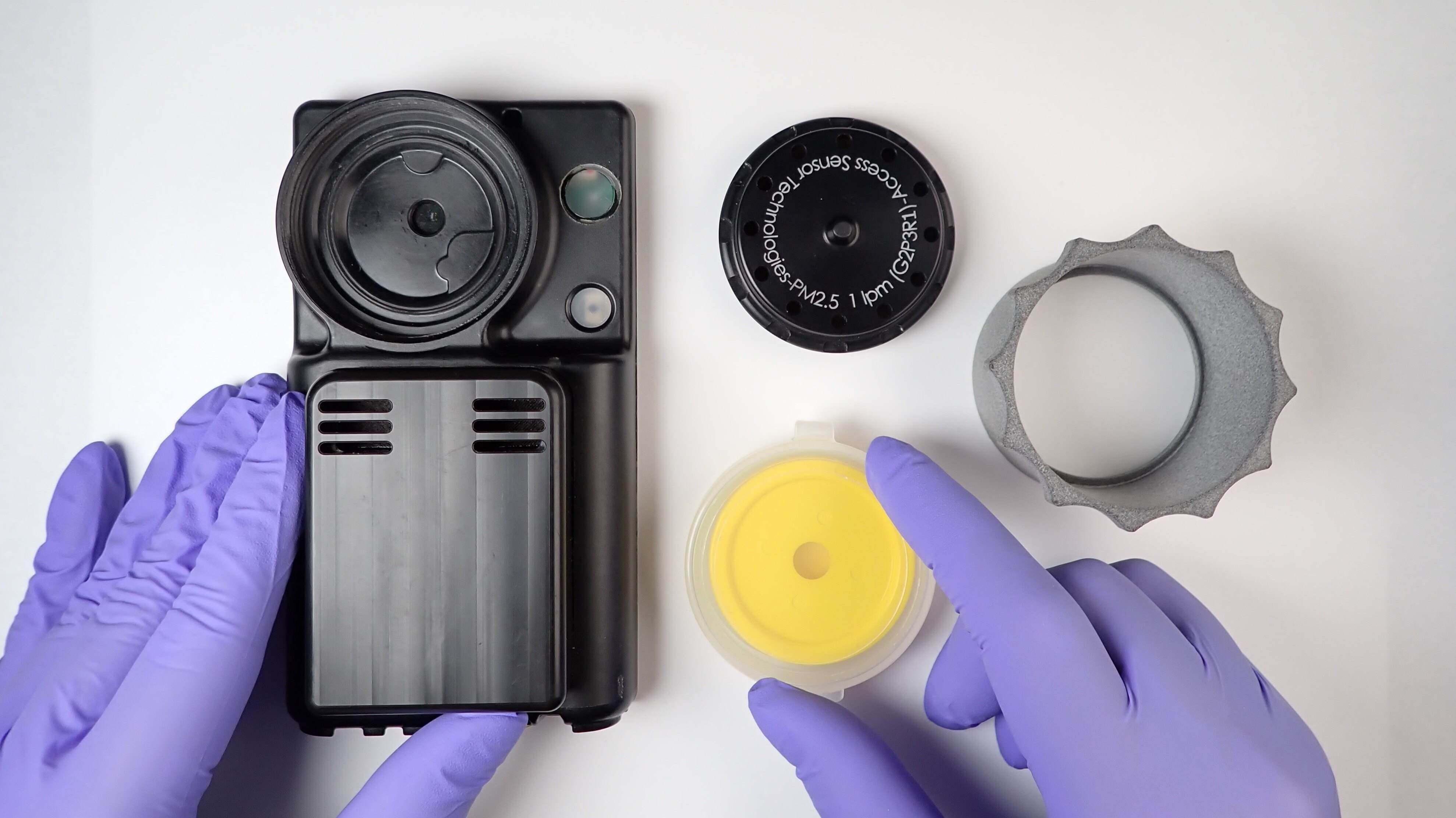 A photograph of a person getting ready to install a filter cartridge in an air sampler